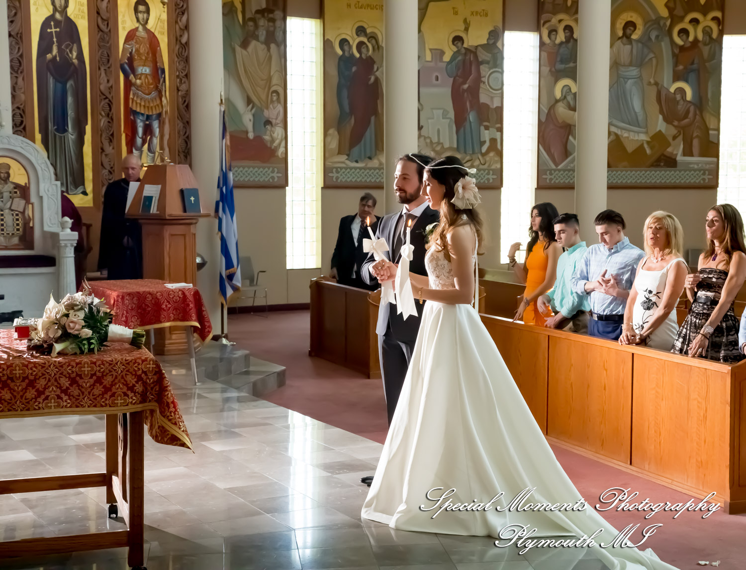 Bride and groom exchanging vows under the sunlit upper dome during a wedding ceremony at St. Nicholas Greek Orthodox Church in Troy Michigan.