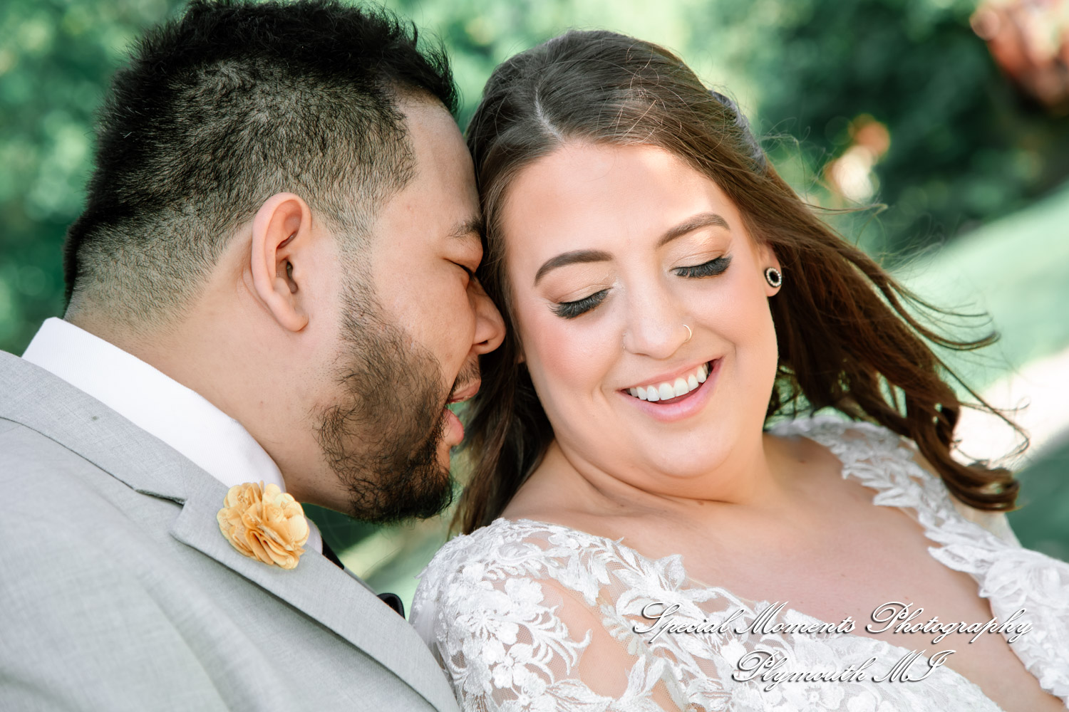 Jimmy & Gina Bride and groom smile while walking across a wooden bridge during their wedding day portraits at Dodge Park in Sterling Heights MI.