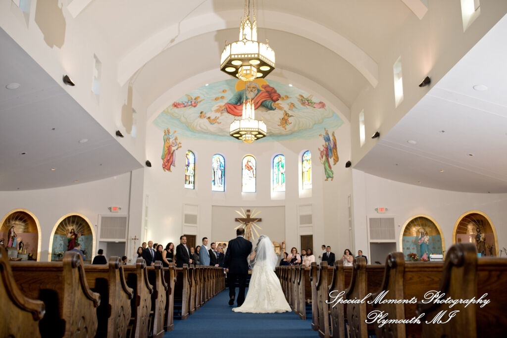 Bride in a custom wedding dress walks down the aisle during a serene St. Thomas Chaldean Catholic Church wedding ceremony in West Bloomfield MI. Bride in a custom wedding dress walks down the aisle during a serene St. Thomas Chaldean Catholic Church wedding ceremony in West Bloomfield MI.