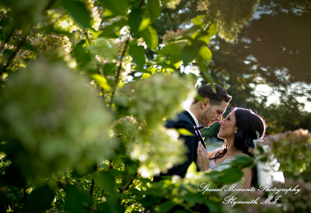 Close up portrait of a bride and groom embracing against the vineyard greenery at a Café Cortina wedding in Farmington Hills MI. Close up portrait of a bride and groom embracing against the vineyard greenery at a Café Cortina wedding in Farmington Hills MI.